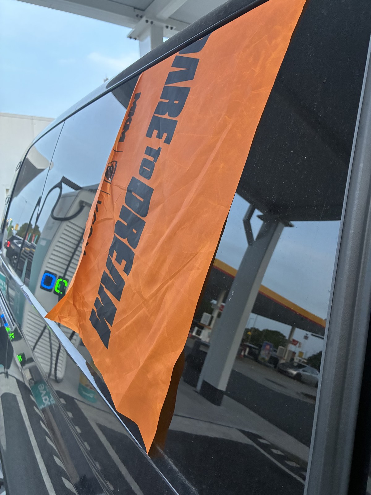 An orange DARE TO DREAM flag photographed on the journey home