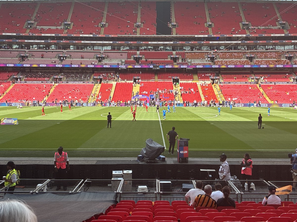 Wembley pitch pre-match, sparse crowd, players warming up